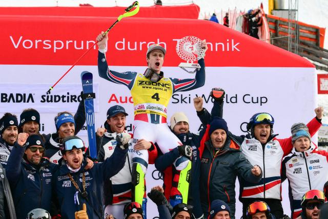 Second placed France's Clement Noel (C) celebrates with teammates on the podium of the Men's Slalom event, as part of the FIS Alpine Ski World Cup 2025-2026, in Alta Badia, northern Italy, on December 22, 2025. (Photo by Stefano RELLANDINI / AFP)