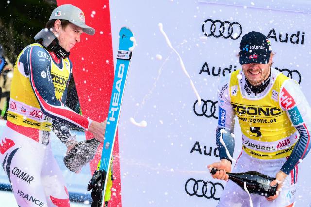 Second placed France's Clement Noel (L) and first placed Norway's Atle Lie Mcgrath celebrate by spraying sparkling wine on the podium of the Men's Slalom event, as part of the FIS Alpine Ski World Cup 2025-2026, in Alta Badia, northern Italy, on December 22, 2025. (Photo by Stefano RELLANDINI / AFP)