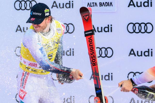 First placed Norway's Atle Lie Mcgrath celebrates by spraying sparkling wine on the podium of the Men's Slalom event, as part of the FIS Alpine Ski World Cup 2025-2026, in Alta Badia, northern Italy, on December 22, 2025. (Photo by Stefano RELLANDINI / AFP)