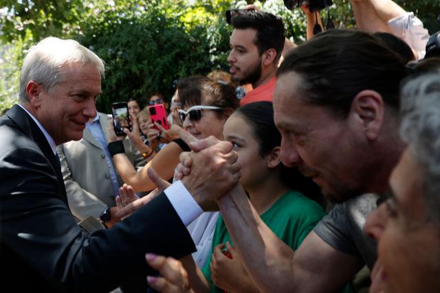 Chile's President-elect Jose Antonio Kast greets supporters after a meeting with Chile's former president (2006-2010 and 2014-2018) Michelle Bachelet in Santiago, on December 22, 2025. (Photo by Raul BRAVO / AFP)