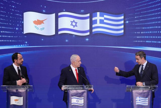 Greek Prime Minister Kyriakos Mitsotakis (R) speaks during a joint press conference with Israeli Prime Minister Benjamin Netanyahu (C) and Cypriot President Nikos Christodoulides (L) after a trilateral meeting in Jerusalem on December 22, 2025. (Photo by ABIR SULTAN / POOL / AFP)