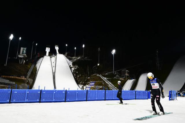 Athletes take part in a training session at the Ski Jumping arena prior the Open Italian Championship of ski jumping in Predazzo, on December 22, 2025. The Ski Jumping arena in Predazzo will host the ski jumping and nordic combined competitions, during the Milano Cortina 2026 Winter Olympic Games. (Photo by Stefano RELLANDINI / AFP)