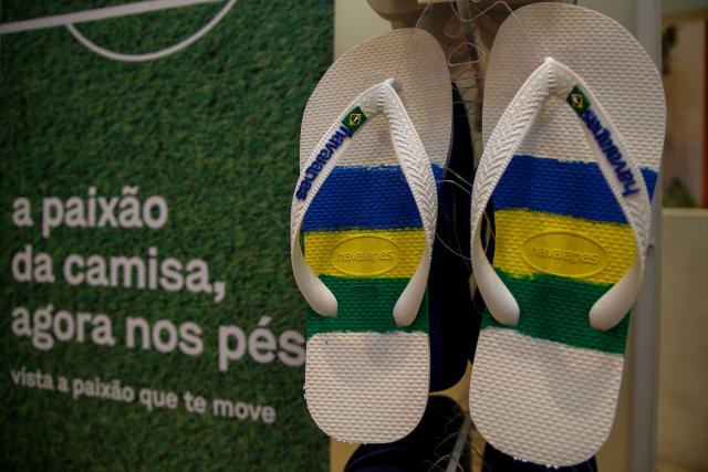 (FILES) Brazilian Havaianas flip-flop are displayed at a store next to a sign reading "The passion of the jersey, now on the feet" in Sao Paulo, Brazil, on November 28, 2022. The famous flip-flop brand Havaianas is facing on December, 2025 a boycott call from Brazilian politicians following an advertisement considered contrary to right-wing views in the run-up to next year's presidential elections. (Photo by Miguel SCHINCARIOL / AFP)