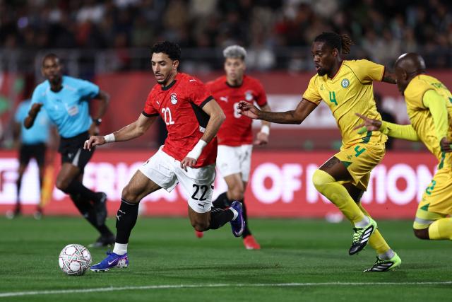 Egypt's forward #22 Omar Marmoush is challenged by Zimbabwe's defender #04 Munashe Garananga during the Africa Cup of Nations (CAN) group B football match between Egypt and Zimbabwe at Adrar Stadium in Agadir on December 22, 2025. (Photo by FRANCK FIFE / AFP)
