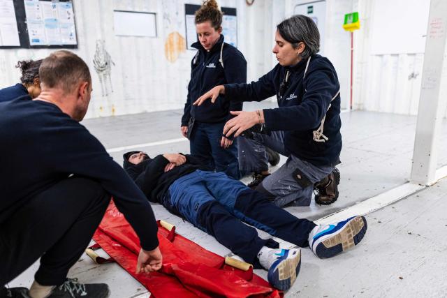 Crew members of the "Ocean Viking" rescue ship, operated by French NGO SOS Mediterranee, take part in a rescue situation exercise in Syracuse, Sicily, southern Italy on December 22, 2025. (Photo by Sameer Al-DOUMY / AFP)