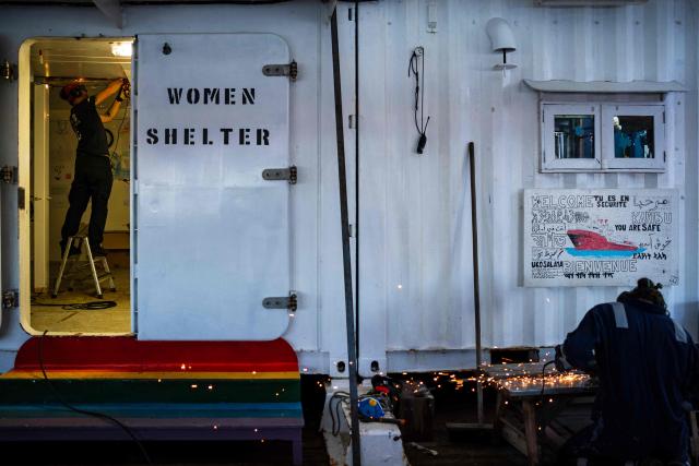 Crew members of the "Ocean Viking" rescue ship, operated by French NGO SOS Mediterranee, maintain women's shelter as part of preparations before sailing in Syracuse, Sicily, southern Italy on December 22, 2025. (Photo by Sameer Al-DOUMY / AFP)