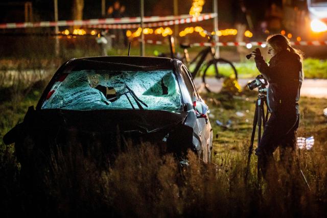 A forensics officer takes photographs of a car at the scene of a serious accident where a car drove through a crowd during a parade in Nunspeet on December 22, 2025. Nine people were hurt, three seriously, in the incident with police saying they did not initially suspect an attack. (Photo by Roland HEITINK / ANP / AFP) / Netherlands OUT