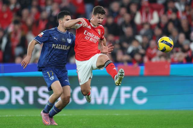 FC Famalicão's Portuguese defender #17 Rodrigo Pinheiro and SL Benfica's Swedish defender #26 Samuel Dahl fight for the ball during the Portuguese League football match between SL Benfica and FC Famalicao at Estadio da Luz in Lisbon on December 22, 2025. (Photo by PATRICIA DE MELO MOREIRA / AFP)