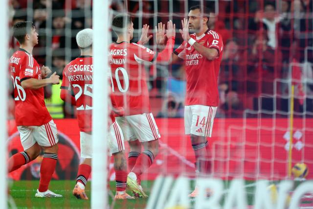 SL Benfica's Greek forward #14 Vangelis Pavlidis (R) celebrates scoring the opening goal during the Portuguese League football match between SL Benfica and FC Famalicao at Estadio da Luz in Lisbon on December 22, 2025. (Photo by PATRICIA DE MELO MOREIRA / AFP)