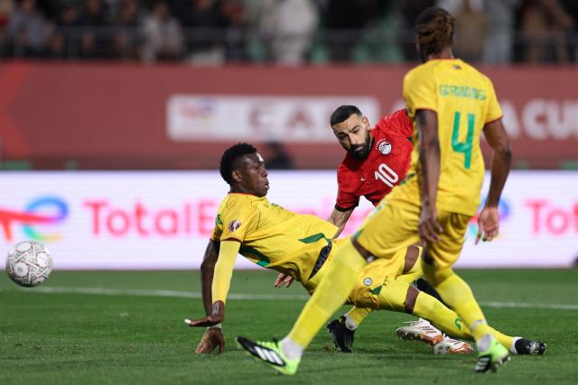 TOPSHOT - Egypt's forward #10 Mohamed Salah scores the team's second goal during the Africa Cup of Nations (CAN) group B football match between Egypt and Zimbabwe at Adrar Stadium in Agadir on December 22, 2025. (Photo by FRANCK FIFE / AFP)