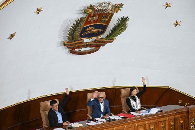 Venezuela's National Assembly President Jorge Rodriguez (C), First Vice President Pedro Infante (L), and Second Vice President America Perez vote during a extraordinary session at the National Assembly in Caracas on December 22, 2025. (Photo by Federico PARRA / AFP)
