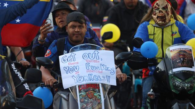 A motorcyclist with an image of US President Donald Trump dressed as a pirate attached to his bike takes part in a motorcade to protest against the United States in Caracas on December 22, 2025. Dressed as pirates, dozens of motorcyclists rode through Caracas on December 22 to protest the seizure of ships carrying Venezuelan oil by the United States as part of its blockade against sanctioned tankers. (Photo by Pedro MATTEY / AFP)
