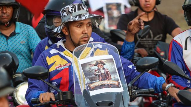 Motorcyclists supporting Venezuelan President Nicolas Maduro take part in a motorcade to protest against the United States in Caracas on December 22, 2025. Dressed as pirates, dozens of motorcyclists rode through Caracas on December 22 to protest the seizure of ships carrying Venezuelan oil by the United States as part of its blockade against sanctioned tankers. (Photo by Pedro MATTEY / AFP)