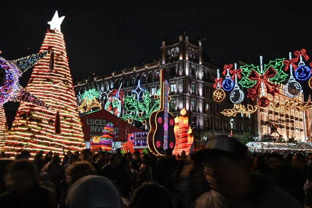 People attend a Christmas light festival at the Zocalo square in Mexico City on December 22, 2025. (Photo by Yuri CORTEZ / AFP)