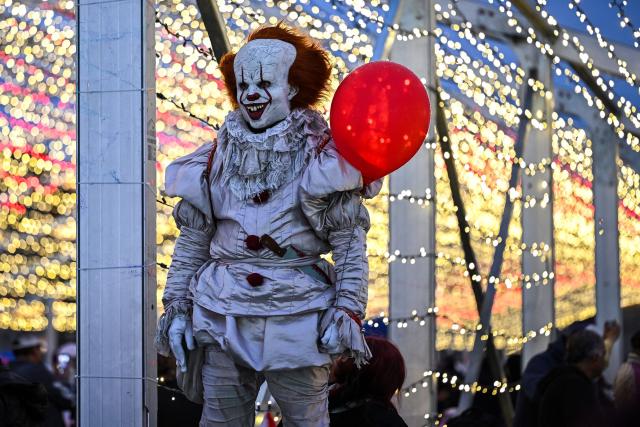 A person dressed as Pennywise, the clown character from the horror novel It, stands during a Christmas light festival at the Zocalo square in Mexico City on December 22, 2025. (Photo by Yuri CORTEZ / AFP)