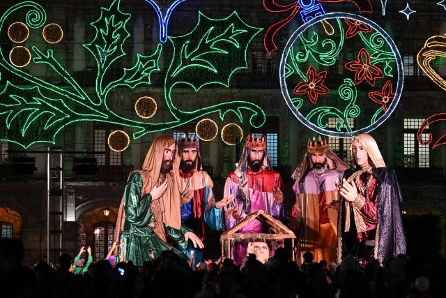 People attend a Christmas light festival featuring giant figures depicting the nativity scene at the Zocalo square in Mexico City on December 22, 2025. (Photo by Yuri CORTEZ / AFP)