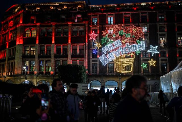 People attend a Christmas light festival at the Zocalo square in Mexico City on December 22, 2025. (Photo by Yuri CORTEZ / AFP)