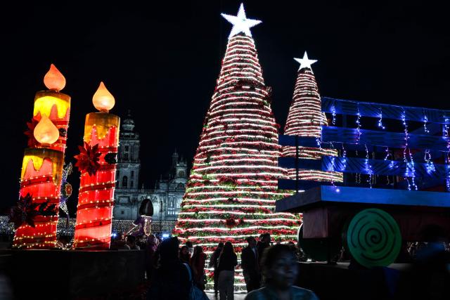People attend a Christmas light festival at the Zocalo square in Mexico City on December 22, 2025. (Photo by Yuri CORTEZ / AFP)
