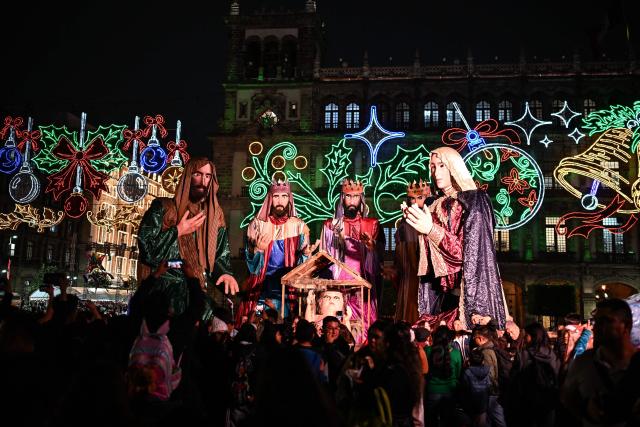 People attend a Christmas light festival featuring giant figures depicting the nativity scene at the Zocalo square in Mexico City on December 22, 2025. (Photo by Yuri CORTEZ / AFP)