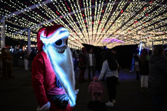 A person dressed as Jack Skellington, the character from the film "The Nightmare Before Christmas", stands during a Christmas light festival at the Zocalo square in Mexico City on December 22, 2025. (Photo by Yuri CORTEZ / AFP)