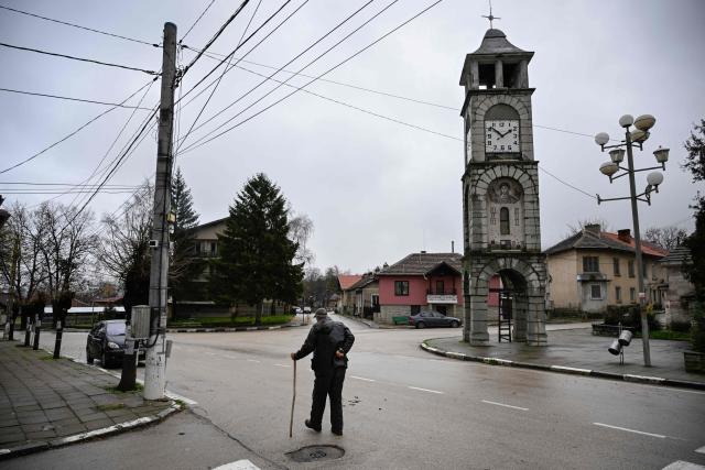 An elderly man walks in the centre of the village of Chuprene, northwestern Bulgaria on December 7, 2025. Bulgaria shaken by political uncertainty, with the latest short-lived government resigning last week -- becomes the single currency area's 21st member on January 1, nearly 19 years after the country of 6.4 million people joined the European Union. (Photo by Nikolay DOYCHINOV / AFP)