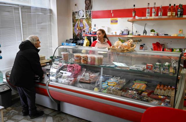 A customer shops in a grocery store in the village of Chuprene, northwestern Bulgaria on December 7, 2025. Bulgaria shaken by political uncertainty, with the latest short-lived government resigning last week -- becomes the single currency area's 21st member on January 1, nearly 19 years after the country of 6.4 million people joined the European Union. (Photo by Nikolay DOYCHINOV / AFP)