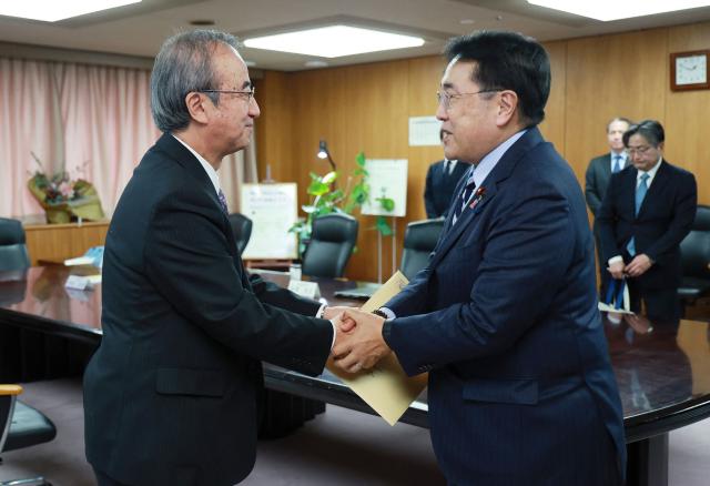 Niigata Prefecture Governor Hideyo Hanazumi (L) meets with Japan's Minister of Economy, Trade and Industry Ryosei Akazawa (R) to discuss the restart of Tokyo Electric Power Company's Kashiwazaki-Kariwa nuclear power plant at the Ministry of Economy, Trade and Industry in Tokyo on December 23, 2025. A Japanese regional assembly backed a plan on December 22 to restart the world's biggest nuclear plant for the first time since the 2011 Fukushima disaster, taking it a step closer to resumption. (Photo by JIJI Press / AFP) / Japan OUT