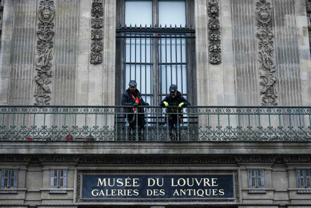 TOPSHOT - Workers install iron window guards on the window of the Gallerie d'Apollon (Apollo's gallery) of the Louvre Museum, on the Quai Francois Mitterrand side, in Paris on December 23, 2025 a few weeks after thieves used a furniture lift to break into the museum. Robbers broke into the Louvre and fled with jewellery on October 19, 2025 morning after arriving on a scooter armed with small chainsaws and used a goods lift to reach the room they were targeting. (Photo by Dimitar DILKOFF / AFP)
