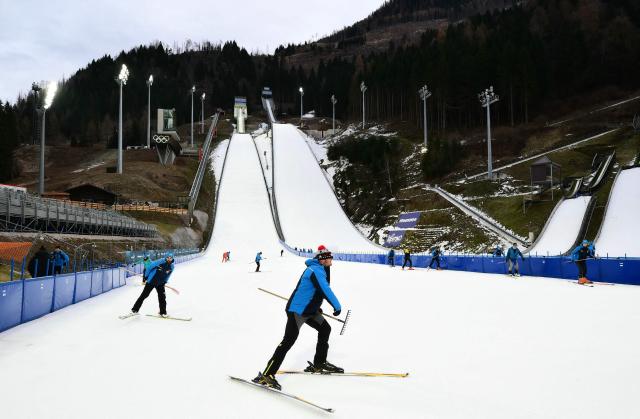 Staff members prepare the slope during a training session at the Ski Jumping arena prior the Open Italian Championship of ski jumping in Predazzo, on December 23, 2025. The Ski Jumping arena in Predazzo will host the ski jumping and nordic combined competitions, during the Milano Cortina 2026 Winter Olympic Games. (Photo by Stefano RELLANDINI / AFP)