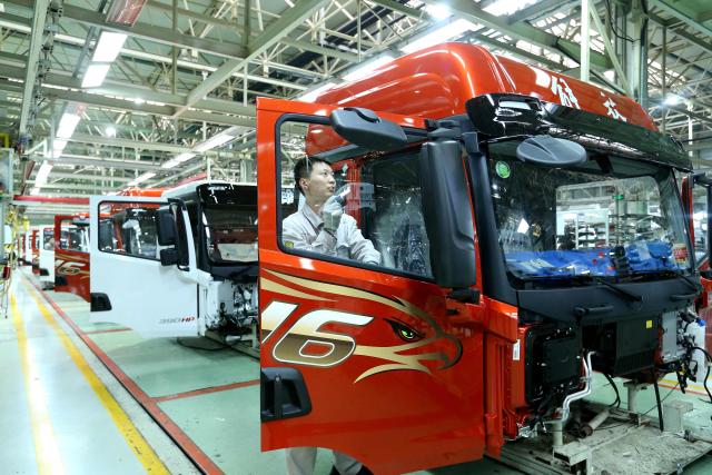 A worker assembles vehicles on the production line of FAW Jiefang Qingdao Automobile in Qingdao, in China’s eastern Shandong province on December 23, 2025. (Photo by AFP) / China OUT