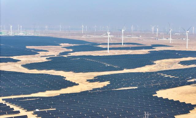 This picture taken on December 22, 2025 shows solar panels and wind turbines at a renewable energy farm in Lingwu, in China's northern Ningxia region. (Photo by AFP) / China OUT