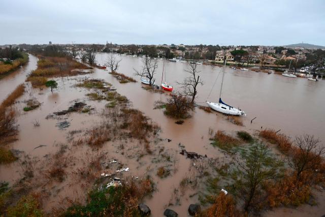 This photograph shows a general view of the Herault river which overflowed following heavy rains in Agde, southern France on December 23, 2025. The Herault department remains under red alert on December 23, 2025, for exceptional flooding, which occurred the previous day following heavy rainfall that is moving away, according to France's weather agency Meteo-France, while the departments of Tarn, Aveyron and Lozere are placed on orange alert for risk of flooding. (Photo by Sylvain THOMAS / AFP)