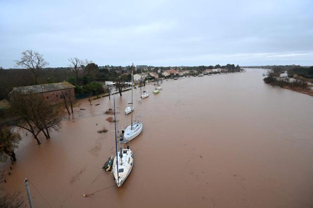 This photograph shows a general view of the Herault river which overflowed following heavy rains in Agde, southern France on December 23, 2025. The Herault department remains under red alert on December 23, 2025, for exceptional flooding, which occurred the previous day following heavy rainfall that is moving away, according to France's weather agency Meteo-France, while the departments of Tarn, Aveyron and Lozere are placed on orange alert for risk of flooding. (Photo by Sylvain THOMAS / AFP)