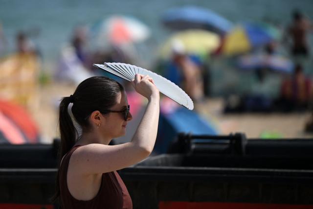 (FILES) Using a fan to keep cool as the temperature rises in Bournemouth on the south coast of England on June 29, 2025. 2025 may have been Britain's hottest on record, with an average temperature above 10 degrees Celsius, the national weather service said on December 23, 2025. Definitive figures for 2025 will be released on January 2, 2026 but as of the final week of this year, the average temperature has been 10.05C. The previous high was 10.03C in 2022, the Met Office said. (Photo by JUSTIN TALLIS / AFP)