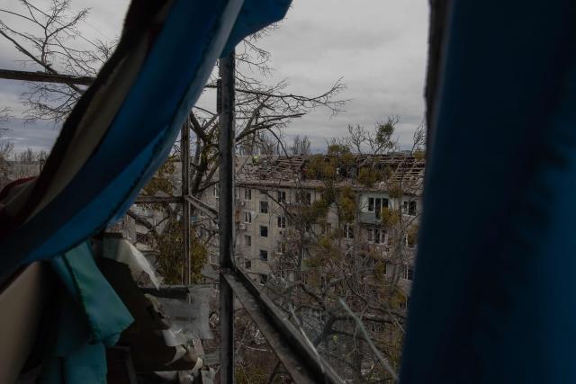 Workers clear debris from the roof of a heavily damaged residential building following a drone strike in Kyiv, on December 23, 2025, amid the Russian invasion of Ukraine. Several Ukrainian regions suffered power cuts in frigid winter weather on December 23, 2025, after Russia launched its latest deadly large-scale attack with drones and missiles, authorities said. (Photo by Roman PILIPEY / AFP)