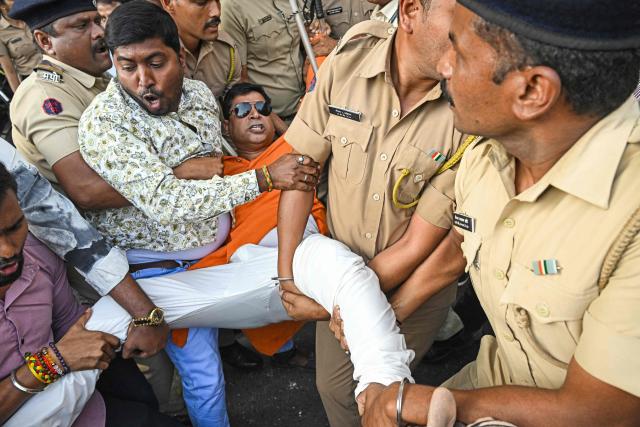 Police detain Vishva Hindu Parishad (VHP) activists during a protest near the Bangladesh Deputy High Commission in Mumbai in Mumbai on December 23, 2025 held to condemn the killing of Hindu garment worker Dipu Chandra Das. On December 18, angry mobs in the majority Muslim nation of Bangladesh's capital of Dhaka attacked the offices of Prothom Alo and the Daily Star, torching parts of the buildings and vandalising the premises of the two publications caught up in surging anti-India sentiment in the wake of popular student leader Sharif Osman Hadi's death. The violence also saw Hindu garment worker Das killed following allegations of blasphemy. (Photo by Indranil MUKHERJEE / AFP)