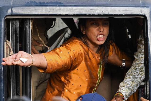 A detained Vishva Hindu Parishad (VHP) activist shouts slogans from a police vehicle during a protest near the Bangladesh Deputy High Commission in Mumbai on December 23, 2025 held to condemn the killing of Hindu garment worker Dipu Chandra Das. On December 18, angry mobs in the majority Muslim nation of Bangladesh's capital of Dhaka attacked the offices of Prothom Alo and the Daily Star, torching parts of the buildings and vandalising the premises of the two publications caught up in surging anti-India sentiment in the wake of popular student leader Sharif Osman Hadi's death. The violence also saw Hindu garment worker Das killed following allegations of blasphemy. (Photo by Indranil MUKHERJEE / AFP)