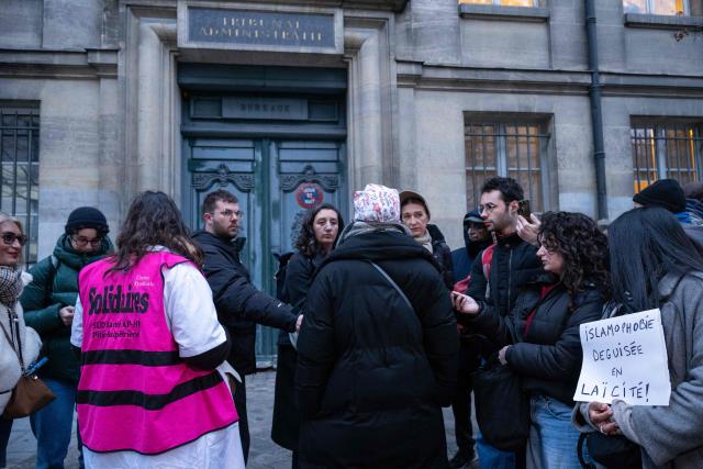 Nurse Majdouline dismissed from the civil service for wearing a skullcap speaks to journalists in front of the administrative court in Paris on December 23, 2025. (Photo by BERTRAND GUAY / AFP)
