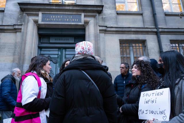 Nurse Majdouline dismissed from the civil service for wearing a skullcap speaks to journalists in front of the administrative court in Paris on December 23, 2025. (Photo by BERTRAND GUAY / AFP)