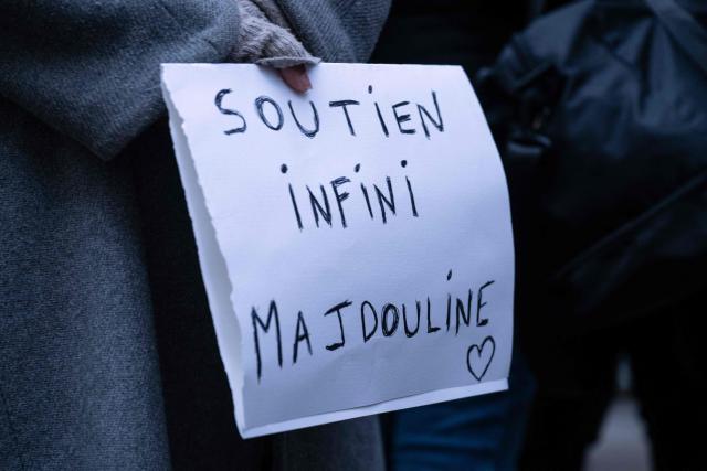 A person holds a sign reading "Endless support to Majdouline" to show support to nurse Majdouline who was dismissed from the civil service for wearing a skullcap speaks to journalists in front of the administrative court in Paris on December 23, 2025. (Photo by BERTRAND GUAY / AFP)