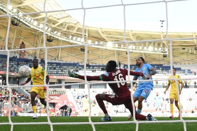 Democratic Republic Of Congo's forward #10 Theo Bongonda scores a goal in front of Benin's goalkeeper #16 Saturnin Allagbe during the Africa Cup of Nations (CAN) Group D football match between Democratic Republic of Congo and Benin at Al Medina Stadium in Rabat on December 23, 2025. (Photo by SEBASTIEN BOZON / AFP)