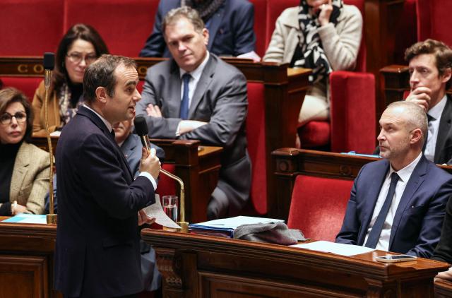 France's Prime Minister Sebastien Lecornu (C) speaks during a session of questions to the government at The National Assembly, France's lower house parliament, in Paris on December 23, 2025. (Photo by Thomas SAMSON / AFP)