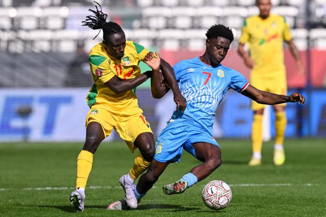 Benin's defender #11 Abdoul Rachid Moumini vies with Democratic Republic Of Congo's midfielder #07 Nathanael Mbuku during the Africa Cup of Nations (CAN) Group D football match between Democratic Republic of Congo and Benin at Al Medina Stadium in Rabat on December 23, 2025. (Photo by SEBASTIEN BOZON / AFP)
