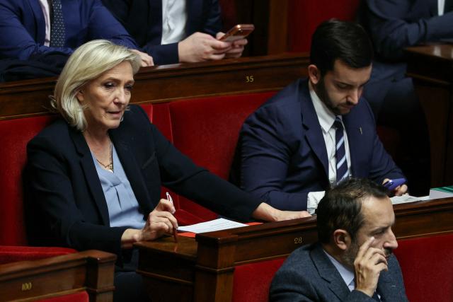 President of Rassemblement National parliamentary group Marine Le Pen (L), Rassemblement National's MP Jean-Philippe Tanguy (R) and Rassemblement National's MP and National Assembly vice-president Sebastien Chenu (DOWN) attend a session of questions to the government at The National Assembly, France's lower house parliament, in Paris on December 23, 2025. (Photo by Thomas SAMSON / AFP)