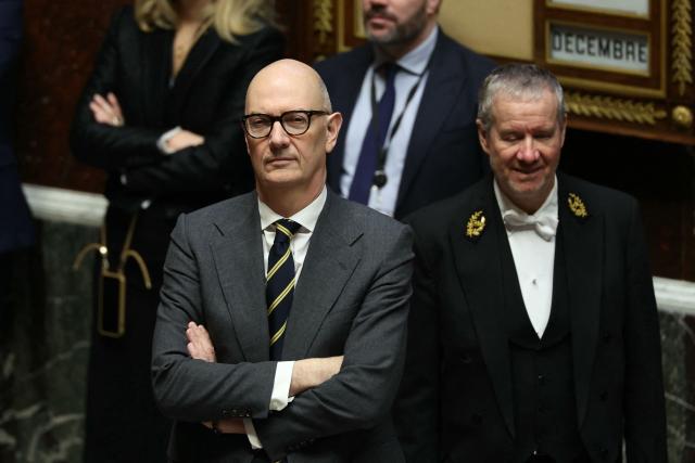 France's Economy and Finance Minister Roland Lescure (L) stands during a session of questions to the government at The National Assembly, France's lower house parliament, in Paris on December 23, 2025. (Photo by Thomas SAMSON / AFP)