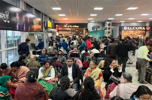 Stranded passengers wait amid flight cancellations and delays owing to dense fog at the Lal Bahadur Shastri International Airport in Varanasi on December 23, 2025. (Photo by Niharika KULKARNI / AFP)