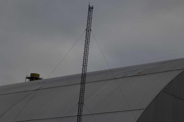 This photo shows the area damaged from a drone attack on February 14, 2025, to the containment vessel of the New Safe Confinement (NSC) which contains radiation from the remains of reactor 4 of the former Chernoby Nuclear Power Plant, in Chernoby, on December 22, 2025, amid the Russian invasion of Ukraine. The Chernobyl Nuclear Power Plant director said on December 23, 2025, fully restoring the internal radiation shelter could take three to four years, after a hit earlier this year punched a hole in the outer radiation shell, triggering a warning from the International Atomic Energy Agency (IAEA) that it had "lost its primary safety functions." And warned that another Russian hit could see the inner shell collapse. (Photo by Tetiana DZHAFAROVA / AFP)