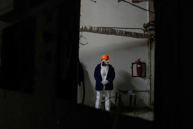 A worker stands in one of the rooms of the Chernobyl Nuclear Power Plant, in Chernobyl, on December 22, 2025, amid the Russian invasion of Ukraine. The Chernobyl Nuclear Power Plant director said on December 23, 2025, fully restoring the internal radiation shelter could take three to four years, after a hit earlier this year punched a hole in the outer radiation shell, triggering a warning from the International Atomic Energy Agency (IAEA) that it had "lost its primary safety functions." And warned that another Russian hit could see the inner shell collapse. (Photo by Tetiana DZHAFAROVA / AFP)