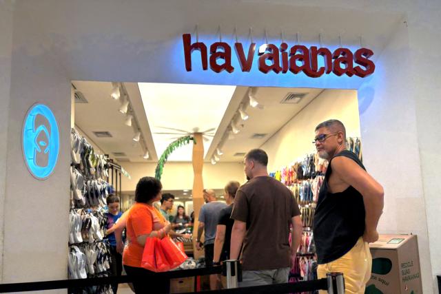 People make a line to get inside a Havaianas store at a mall in the north zone of Rio de Janeiro, Brazil, on December 23, 2025. Havaianas is facing a boycott call from Brazilian politicians following an advertisement considered contrary to right-wing views in the run-up to next year's presidential elections. (Photo by MAURO PIMENTEL / AFP)