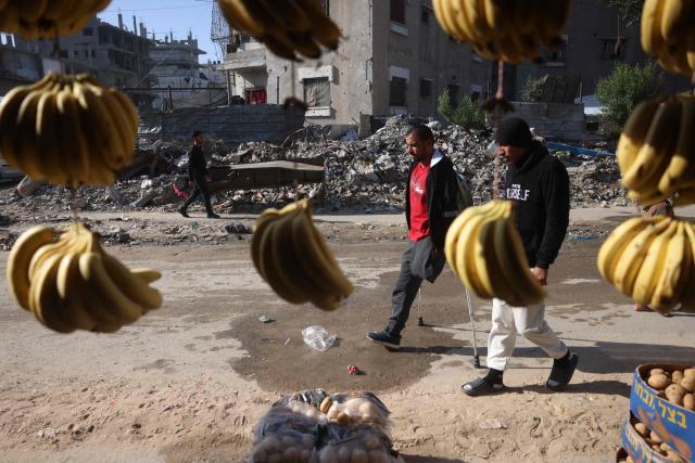 Bassam Omar Shaheen, 37, walks in the street in Gaza City's Al-Saftawi neighbourhood in the northern Gaza Strip on December 23, 2025. Omar was injured in an attack on a school on November 3, 2023 in the Al-Saftawi neighbourhood in the northern Gaza Strip, in which his father and mother were killed, and his leg was amputated as a result. He has been waiting for two years to travel to complete treatment for his hand, which requires surgery due to damage to his fingers and palm. The war was sparked by Hamas's October 7, 2023 attack on Israel, which resulted in the deaths of 1,221 people. Israel's retaliatory assault on Gaza has killed over 70,000 people, according to figures from the health ministry that the UN considers reliable. (Photo by Bashar Taleb / AFP)
